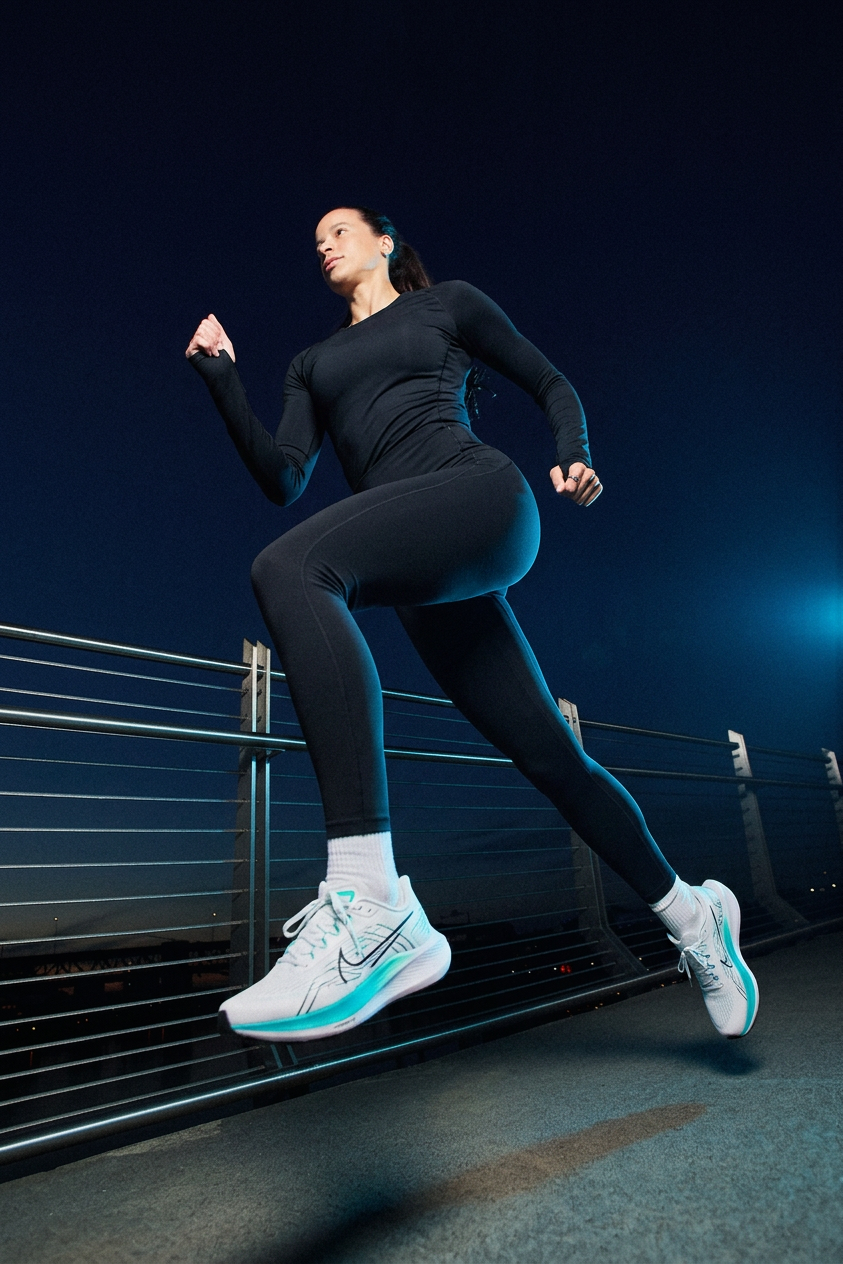 Athletic woman sprinting on night bridge, teal shoes
