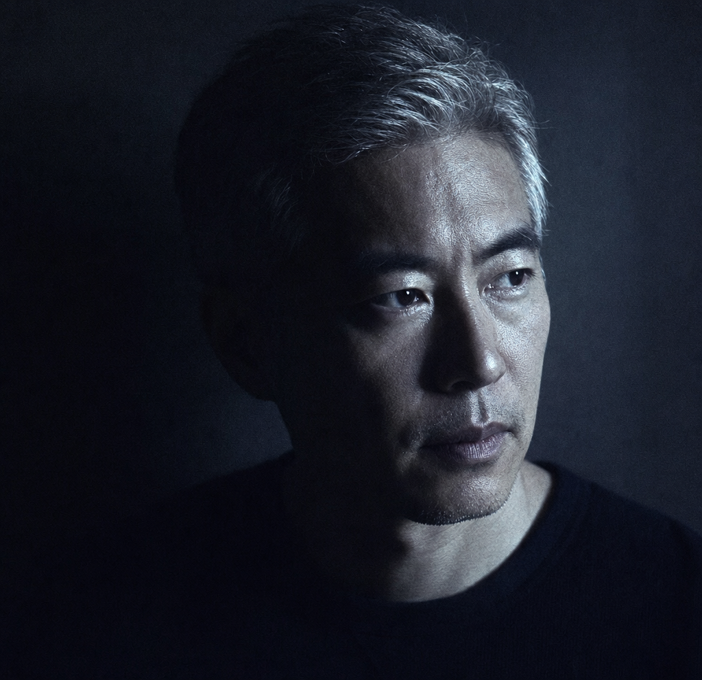 Contemplative silver-haired man in cool chiaroscuro