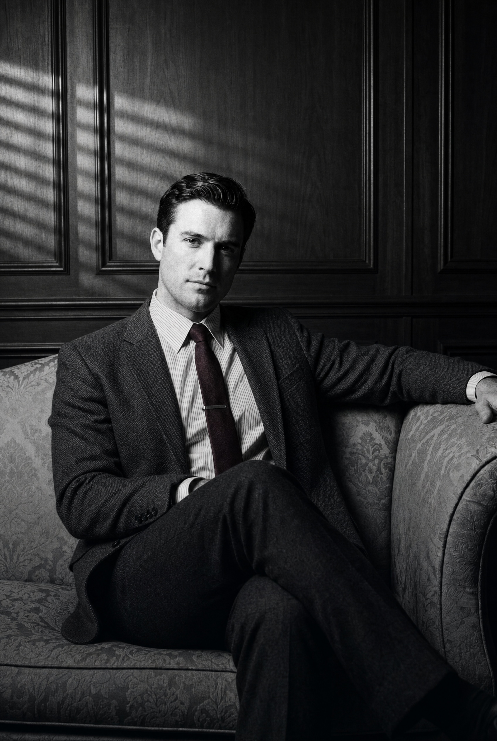 Dapper man with charcoal blazer on vintage sofa