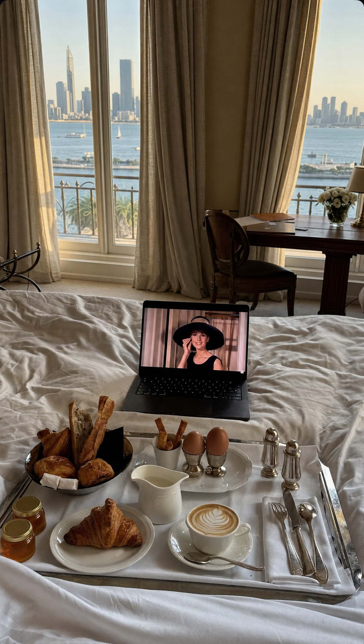 Luxury breakfast tray on unmade bed with latte