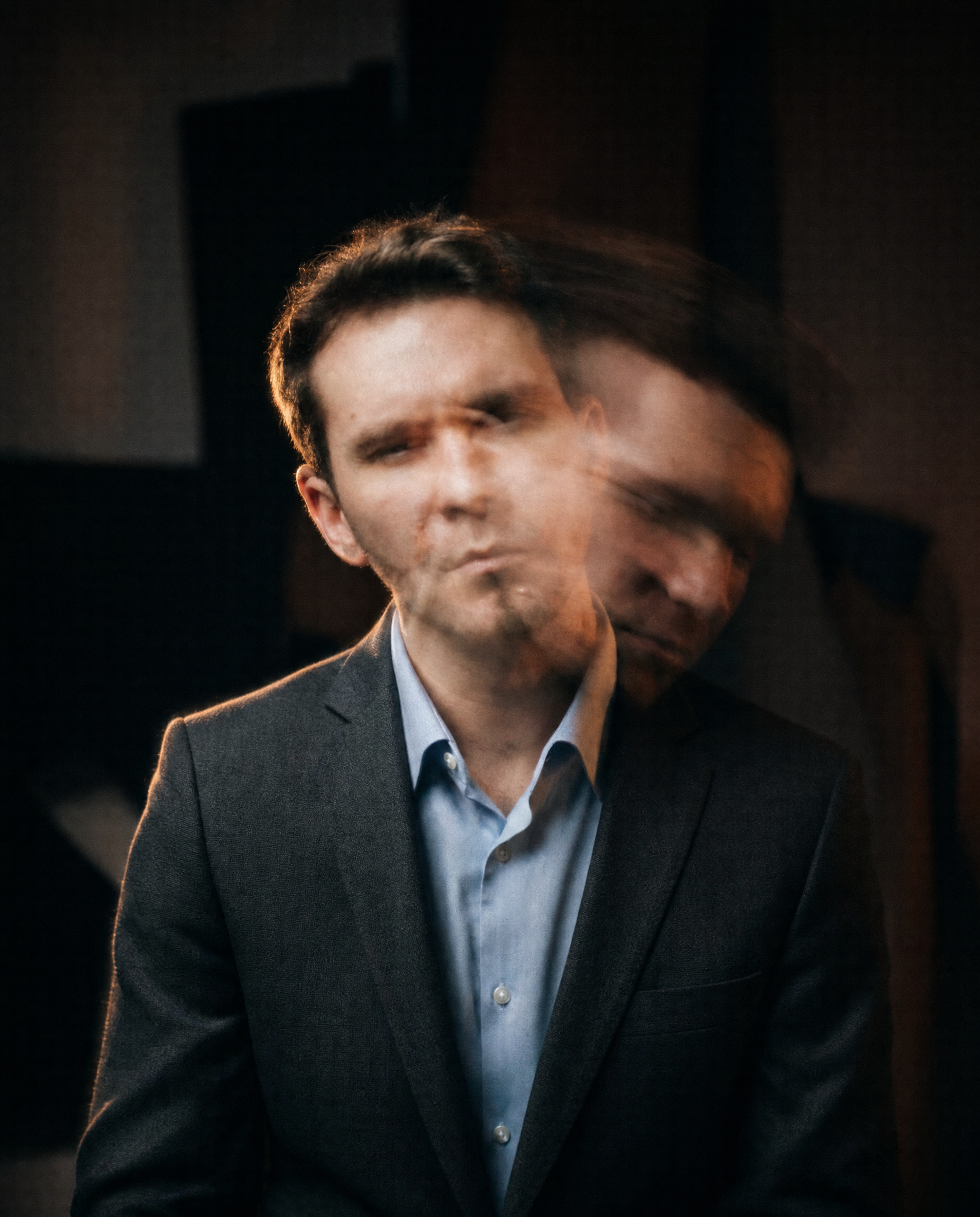 Man in charcoal suit with blue shirt motion blur