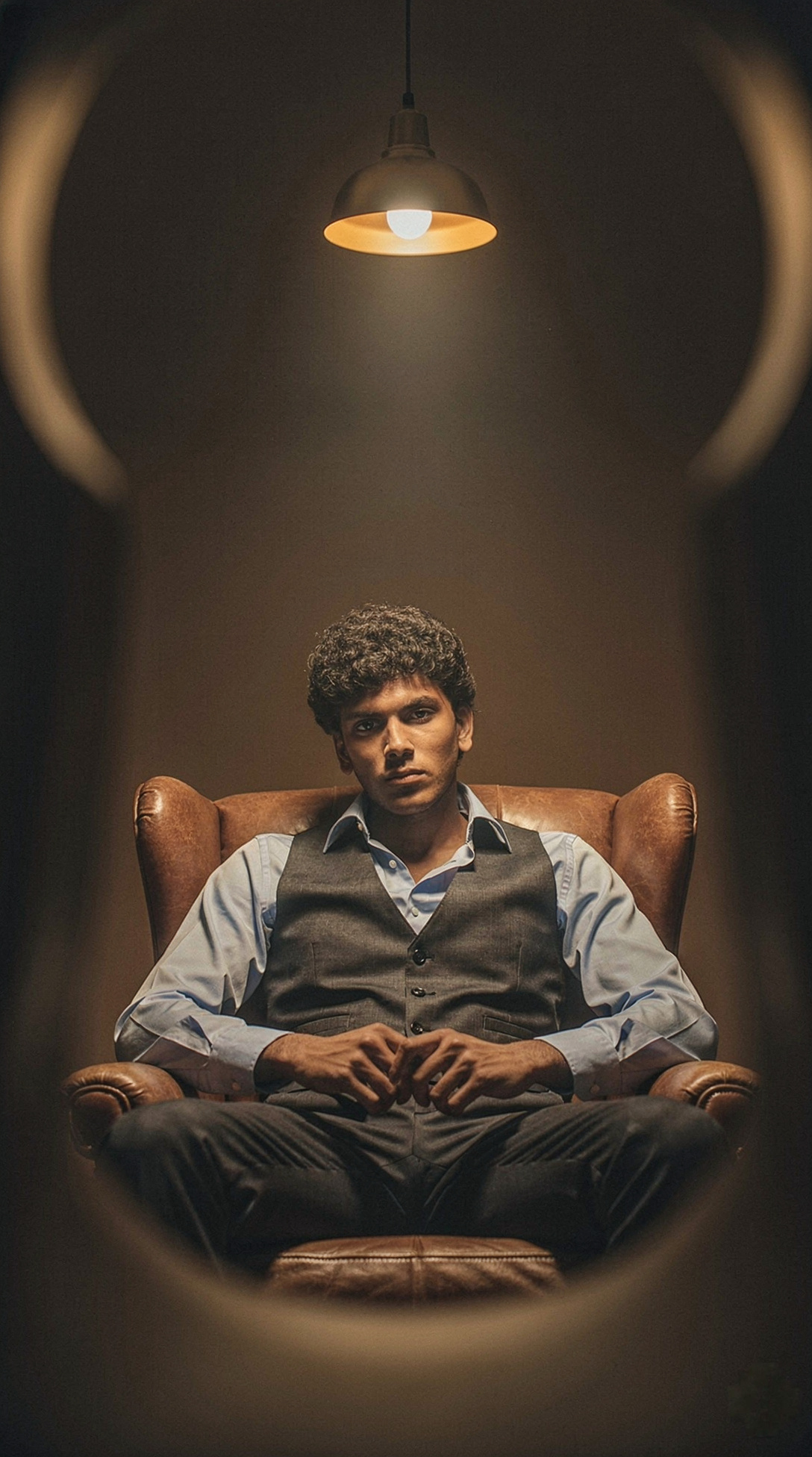 Man in Leather Armchair With Blue Shirt Under Lamp — flux-2-pro