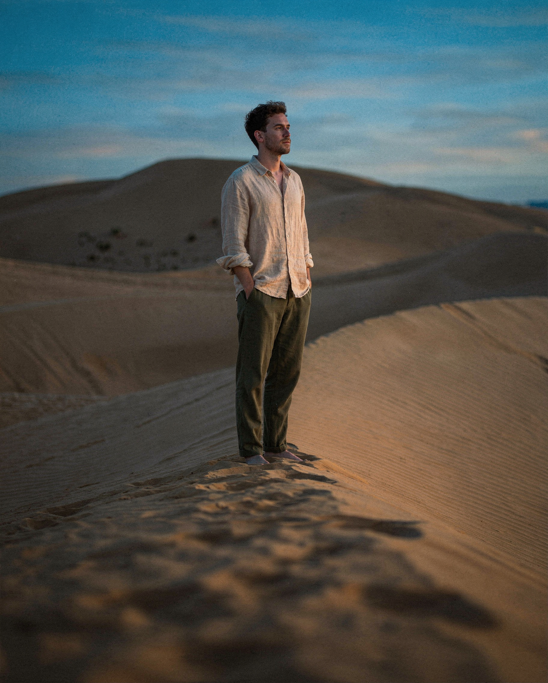 Man on sand dune in blue hour — flux-2-pro