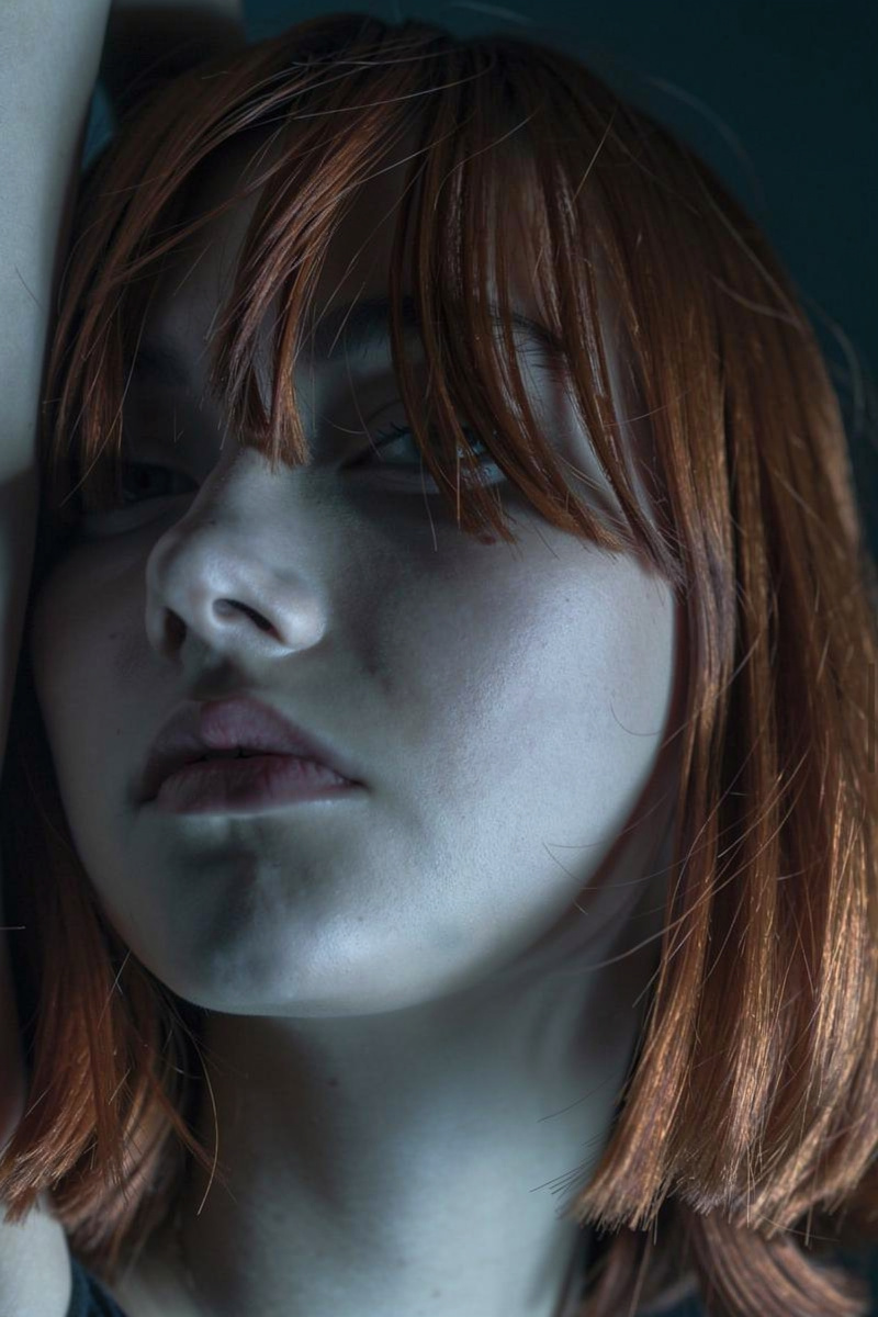 Moody editorial portrait with blue-gray light