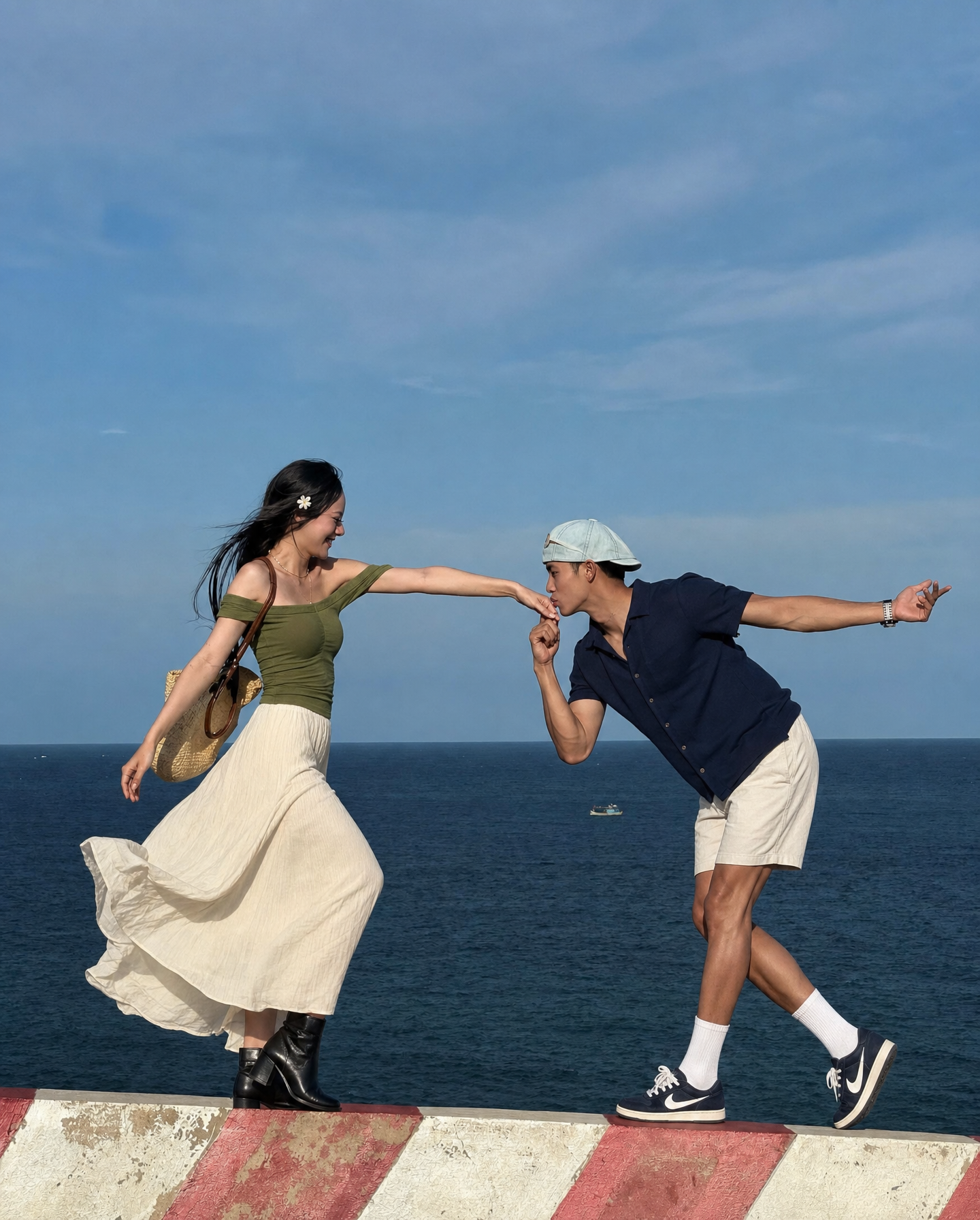 Playful couple on seaside ledge