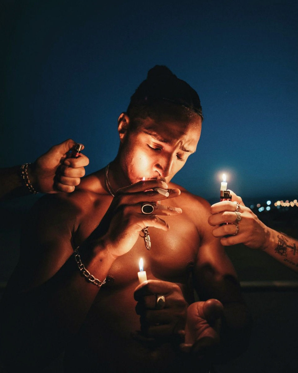 Shirtless Man With Hands Holding Amber Candles