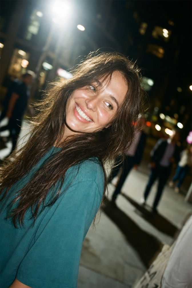 Smiling woman in teal top with flash