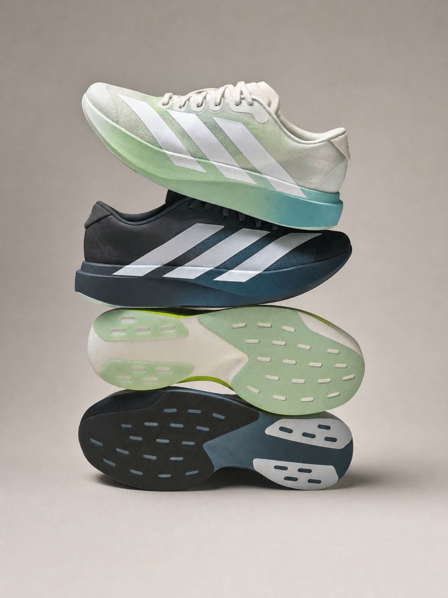 Two stacked Adidas running shoes, mint-to-aqua gradient