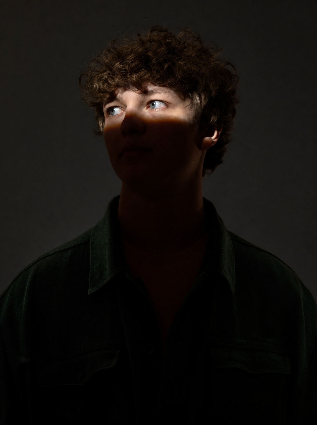 Young man with curly light-brown hair, green shirt
