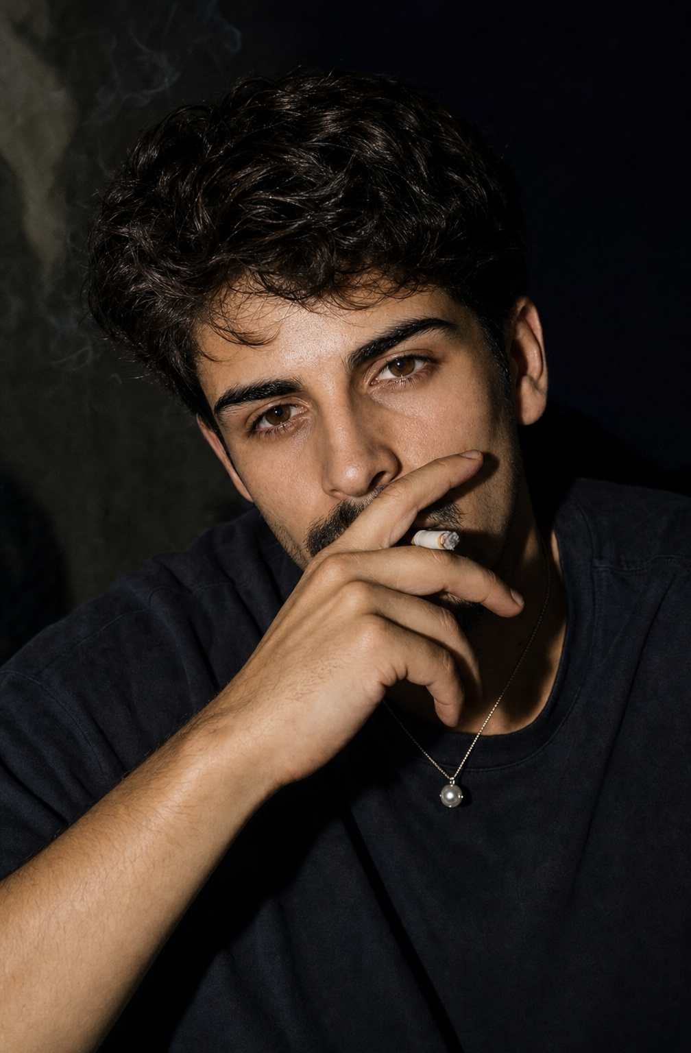 Young man with short wavy hair, cigarette near mouth