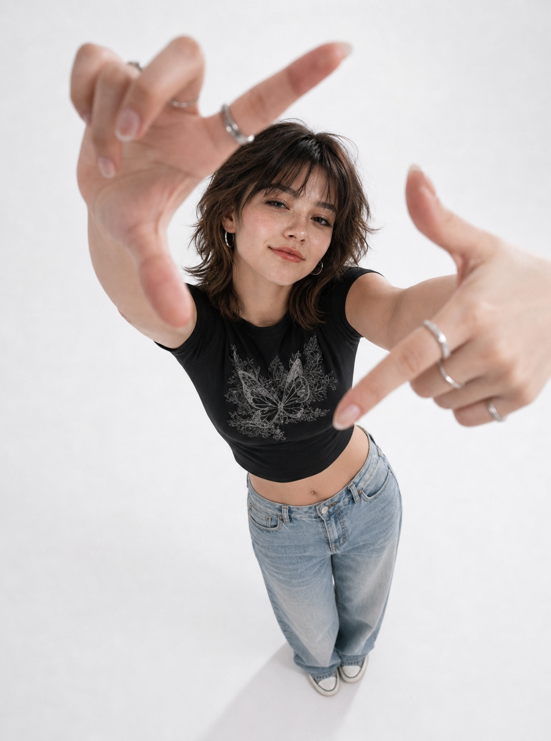 Young woman reaching toward camera in black tee